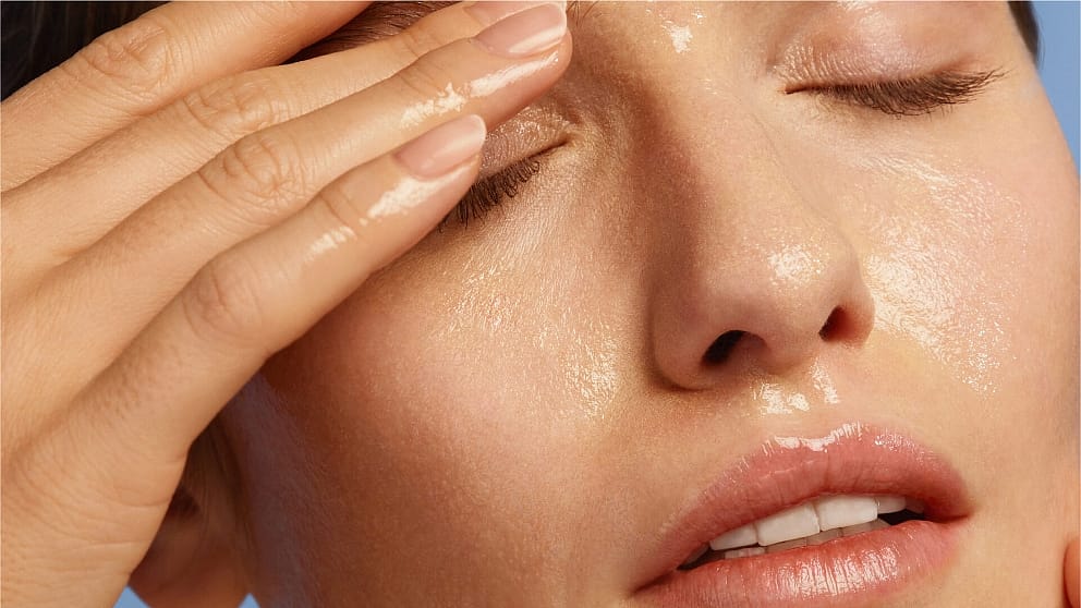 woman cleaning her face with cotton pad